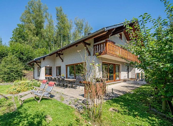 Enjoy the terrace of Leora Cosy vacation home in Membre, Ardennes, overlooking the green hills and an inviting garden.