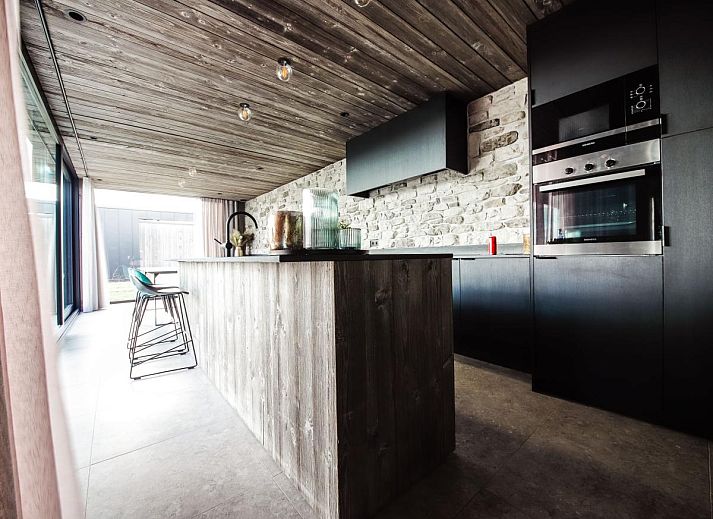 Modernes Wohnzimmer im Ferienhaus La Ruree, Heure, Ardennen, Belgien, mit stilvoller Einrichtung und grossen Fenstern fuer natuerliches Licht.