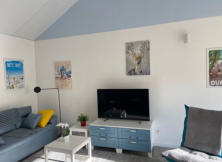 Gemuetliches Wohnzimmer im Ferienhaus Modernes Chalet in Heure, Ardennen, mit stimmungsvoller Weihnachtsdekoration und moderner Beleuchtung.