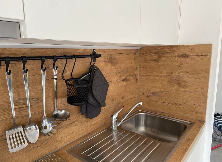 Gemuetliches Wohnzimmer im Ferienhaus Modernes Chalet in Heure, Ardennen, mit stimmungsvoller Weihnachtsdekoration und moderner Beleuchtung.