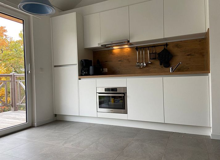 Gemuetliches Wohnzimmer im Ferienhaus Modernes Chalet in Heure, Ardennen, mit stimmungsvoller Weihnachtsdekoration und moderner Beleuchtung.