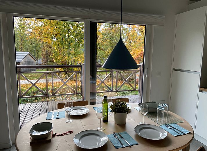 Ferienhaus Modernes Chalet fuer 4 Personen in Heure, Ardennen, Belgien, mit Holzveranda und Blick auf die waldreiche Umgebung.