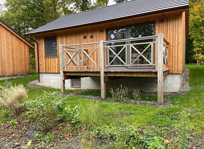 Ferienhaus Modernes Chalet fuer 4 Personen in Heure, Ardennen, Belgien, umgeben von waldreicher Natur mit einer einladenden Veranda.