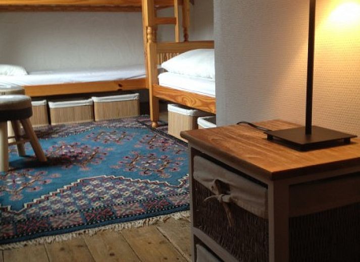 Ingang van vakantiehuis Falaen in de Ardennen, Namen, Belgie met stenen gevel en groene struiken.