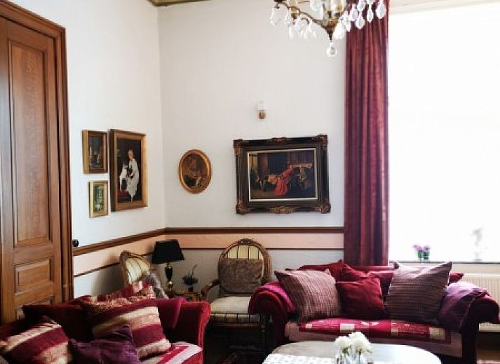 Klassieke piano in vakantiehuis Falaen, Falaen, Ardennen met kunstwerken aan de muur.