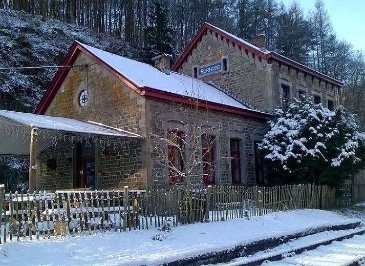 Charmantes Ferienhaus in Purnode, in den Ardennen, Belgien, mit rustikaler Steinfassade und einladender roter Tuer.