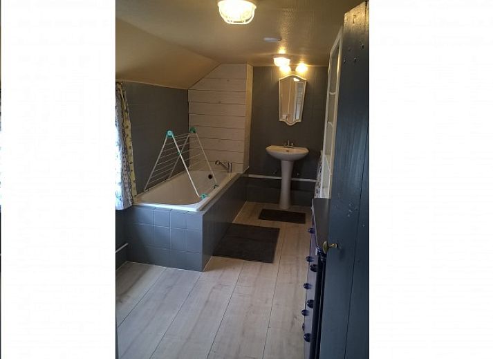 Gezellige woonkamer van vakantiehuis Le Colombage in Honnay, Ardennen, met houtkachel en tafelvoetbal voor een ontspannen verblijf.