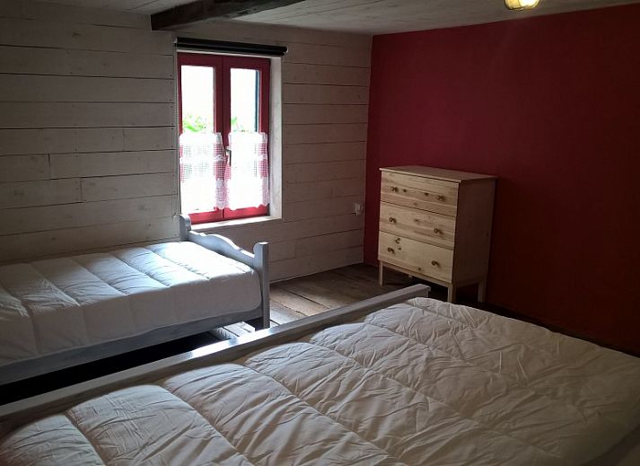 Gezellige woonkamer van vakantiehuis Le Colombage in Honnay, Ardennen, met houtkachel en tafelvoetbal voor een ontspannen verblijf.