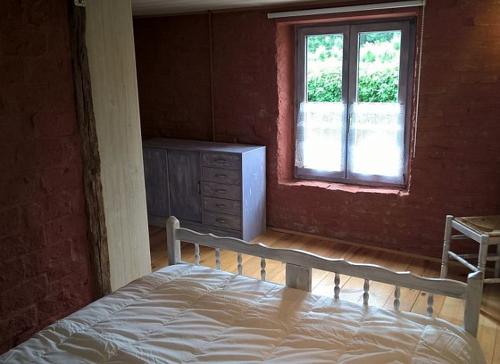 Gezellige woonkamer van vakantiehuis Le Colombage in Honnay, Ardennen, met houtkachel en tafelvoetbal voor een ontspannen verblijf.