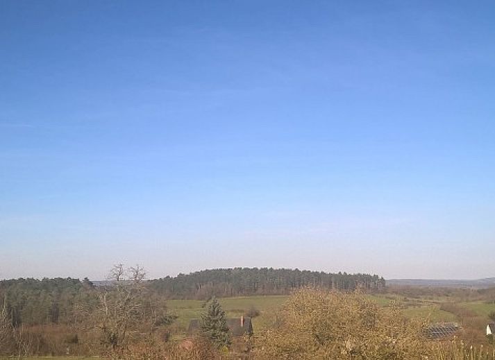 Gezellige binnenruimte van vakantiehuis Le Colombage in Honnay, Ardennen, met rustieke keuken en eetgedeelte.