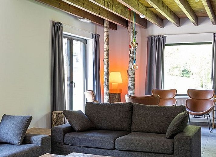 Cozy indoor area of Chalet the Nutcracker in Barvaux-Durbuy, Ardennes, with wood stove and dining area.