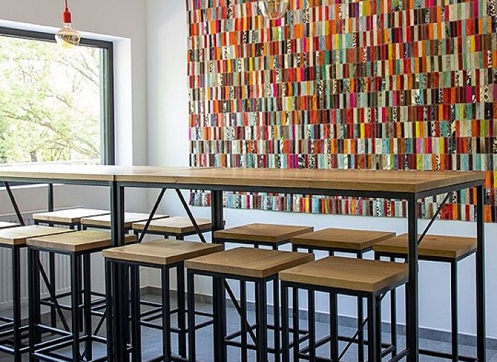 Cozy indoor area of Chalet the Nutcracker in Barvaux-Durbuy, Ardennes, with wood stove and dining area.