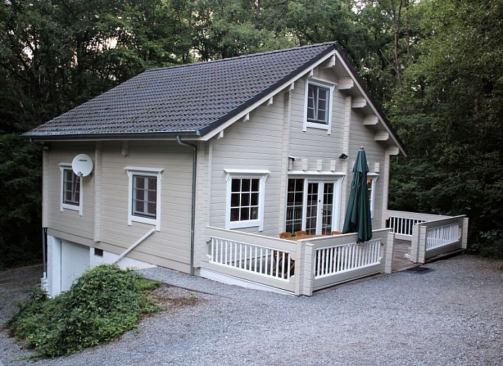 Comfortable sitting area in chalet Alppimaja, Barvaux-sur-Ourthe, Ardennes, with wooden walls and large windows.