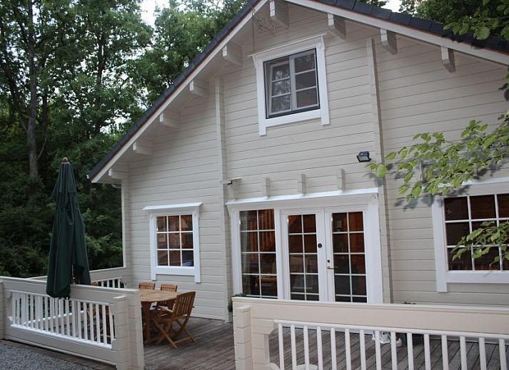 Comfortable sitting area in chalet Alppimaja, Barvaux-sur-Ourthe, Ardennes, with wooden walls and large windows.