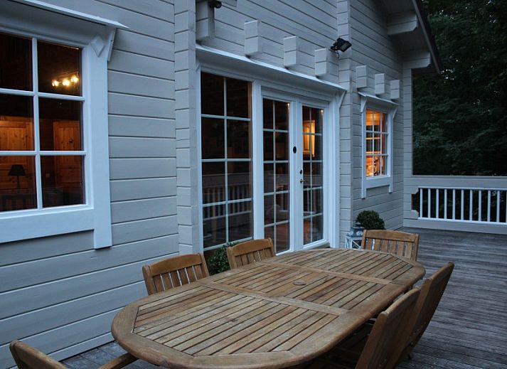 Comfortable sitting area in chalet Alppimaja, Barvaux-sur-Ourthe, Ardennes, with wooden walls and large windows.