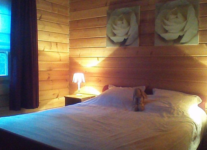 Cozy bedroom with wrought iron bed in chalet Alppimaja, Barvaux-sur-Ourthe, Ardennes, for a peaceful sleep.
