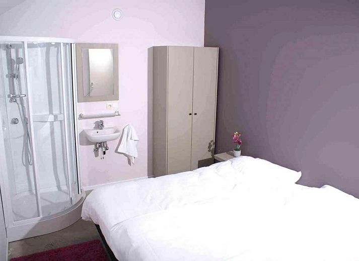 ARD112 vakantiehuis in Vielsalm, Ardennen met stenen gevel en kleurrijke ramen.