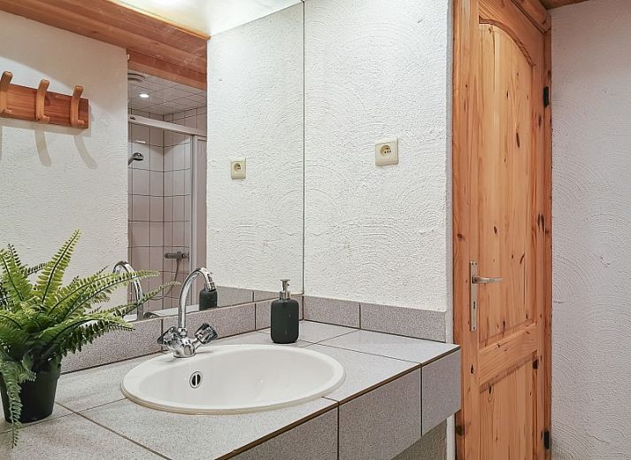 Sfeervolle woonkamer van La Villa in Dochamps, Ardennen, met open haard en boekenplank, Luxemburg, Belgie.