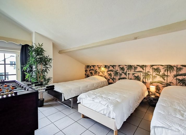 Sfeervolle woonkamer van La Villa in Dochamps, Ardennen, met open haard en boekenplank, Luxemburg, Belgie.