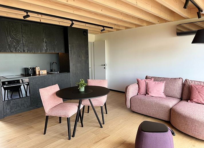 Gezellige woonkamer van Escapade Naturelle in de Ardennen, met uitzicht op terras en natuur.