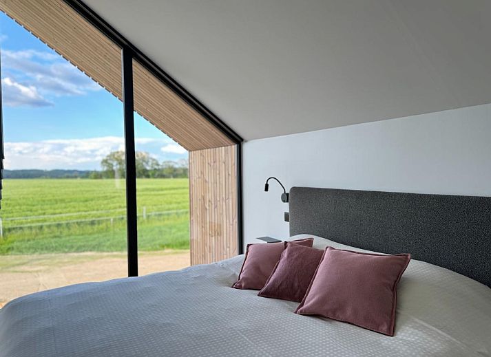 Gezellige woonkamer van Escapade Naturelle in de Ardennen, met uitzicht op terras en natuur.