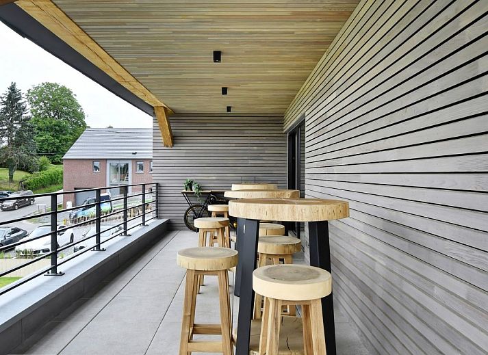 Geniessen Sie luxurioese Entspannung auf der Terrasse des Ferienhauses Durbuy Suites in den Ardennen, Belgien, mit modernem Design und natuerlicher Umgebung.