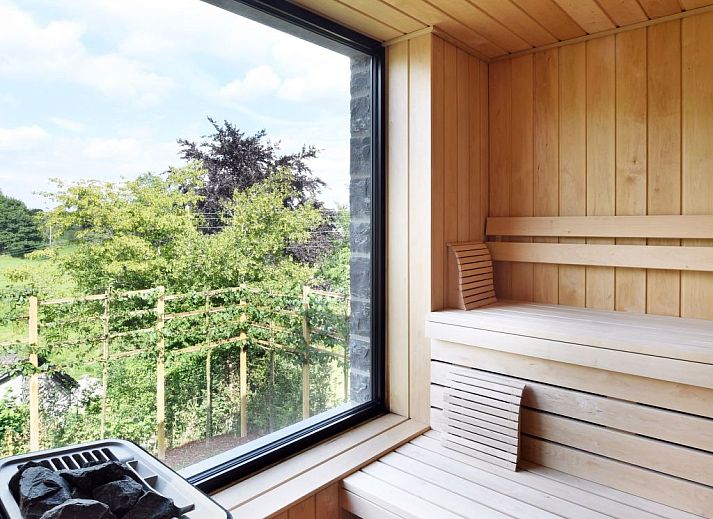 Geniessen Sie luxurioese Entspannung auf der Terrasse des Ferienhauses Durbuy Suites in den Ardennen, Belgien, mit modernem Design und natuerlicher Umgebung.