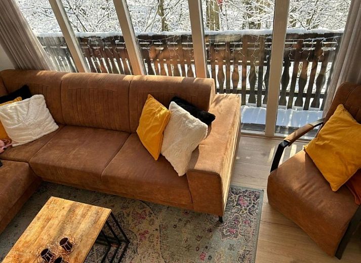 Cozy living room of Chalet Du Bois IV in Durbuy, Ardennes, Belgium with comfortable seating area and views of nature.