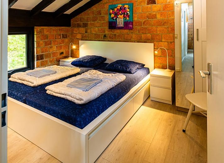 Gezellige woonkamer van Huisje in Izier, een vakantiehuis in de Ardennen, Belgie, met sfeervolle inrichting en uitzicht op de tuin.