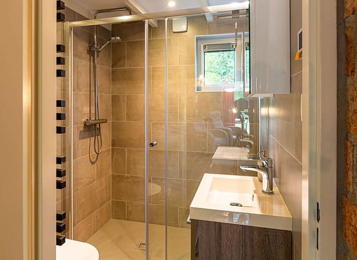 Gezellige woonkamer van Huisje in Izier, een vakantiehuis in de Ardennen, Belgie, met sfeervolle inrichting en uitzicht op de tuin.