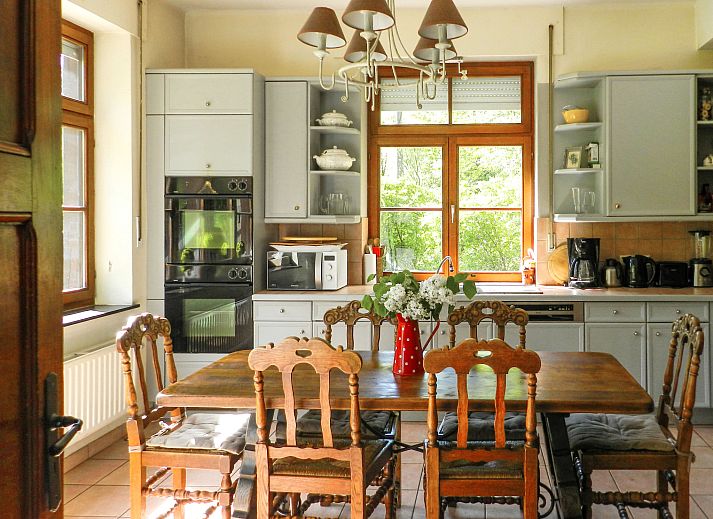 Vakantiehuis La Rochette in Marche-en-Famenne, Ardennen, Belgie, omgeven door groene natuur en blauwe lucht.