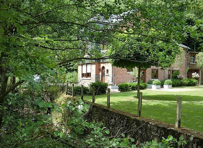 Sfeervolle slaapkamer in Vakantiehuis La Rochette, gelegen in Marche-en-Famenne, Ardennen, Belgie, met rustieke houten meubels.