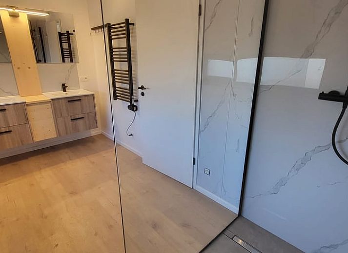 Cottage in Grandmenil, cottage in the Ardennes, Belgium with modern wooden facade and spacious driveway surrounded by nature.