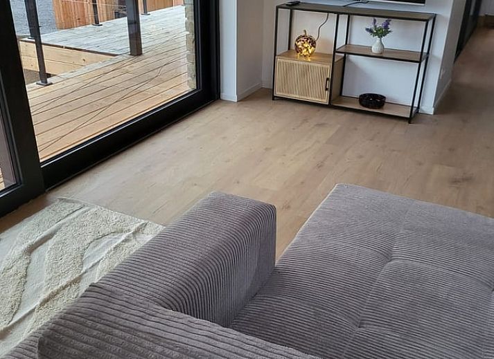 Veranda of Cottage in Grandmenil, located in Ardennes, Belgium, overlooking green nature and sunny garden.