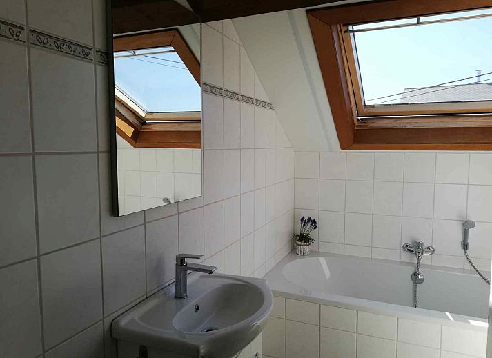 Lichte badkamer in vakantiehuis ARD118, La Roche-en-Ardenne, met dakramen en een bad, gelegen in de Ardennen, Belgie.