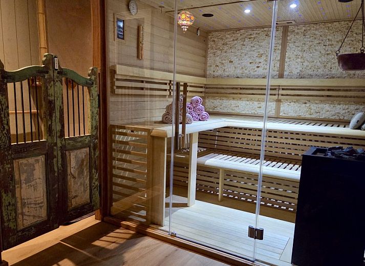 Ruime veranda met houten eettafel bij La Ferme des Fermiers, een vakantiehuis in Erezee, Ardennen.
