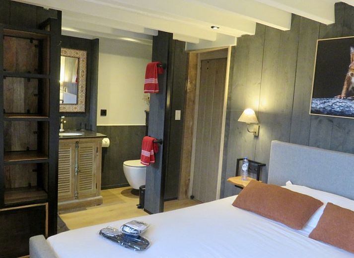 Ruime veranda met houten eettafel bij La Ferme des Fermiers, een vakantiehuis in Erezee, Ardennen.