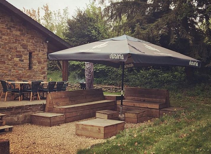 Cottage in Our, Ardennes, Belgium with stone facade and terrace, surrounded by nature.