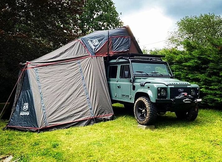Cottage in Our, Ardennes, Belgium with stone facade and terrace, surrounded by nature.