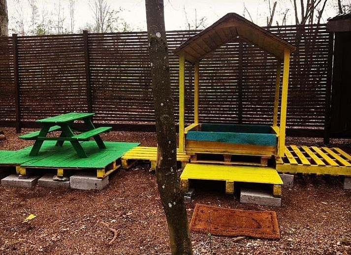 Cozy terrace at cottage in Our, Ardennes, Belgium with wooden seating.