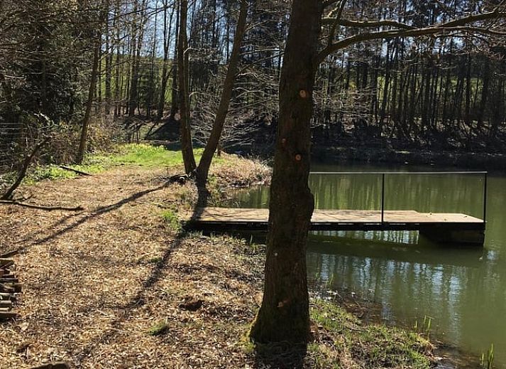 Tent next to all-terrain vehicle at cottage in Our, Ardennes, Belgium, perfect for camping enthusiasts.