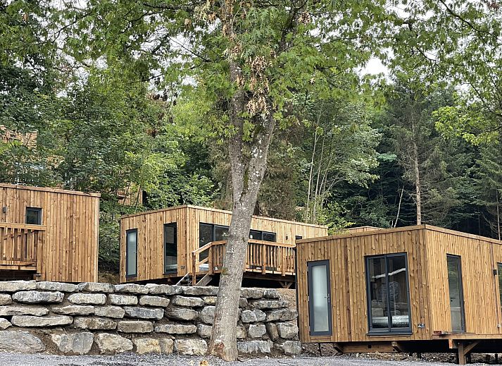 Ecolodge in Bouillon, Ardennen, Belgien, umgeben von Natur, bietet ein rustikales Ferienhaus mit zwei Schlafzimmern und einer einladenden Terrasse.
