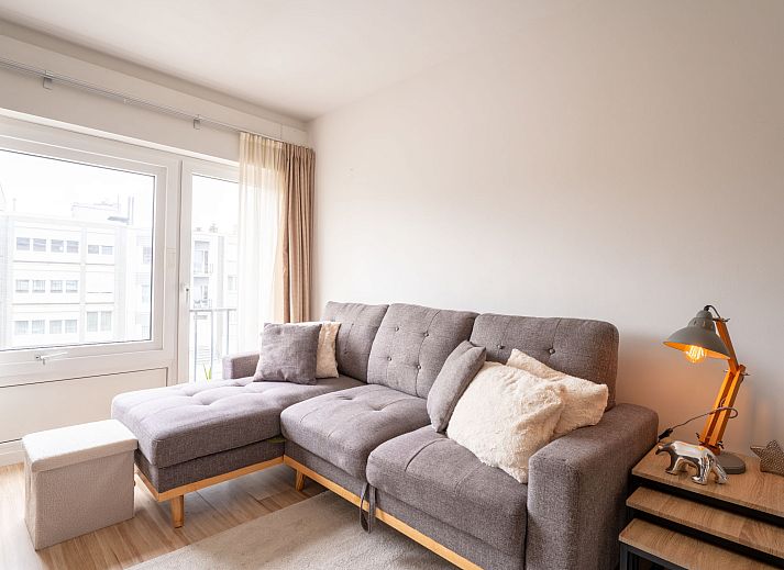 Gezellige woonkamer van Appartement BeachNest in Blankenberge, Belgische kust, met licht interieur en comfortabel meubilair.