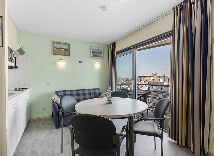 Gezellige woonkamer van Ocean Suites - 714 in Blankenberge, Belgische kust, met uitzicht op de stad vanaf het balkon.