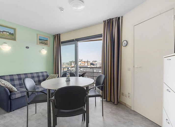 Gezellige woonkamer van Ocean Suites - 714 in Blankenberge, Belgische kust, met uitzicht op de stad vanaf het balkon.