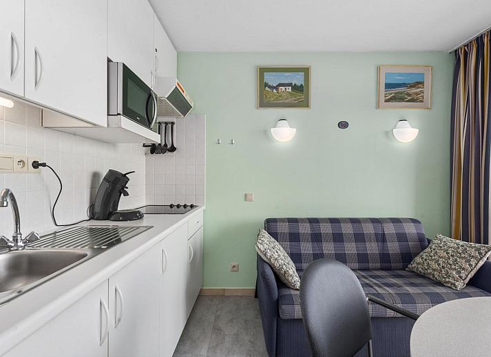 Gezellige woonkamer van Ocean Suites - 714 in Blankenberge, Belgische kust, met uitzicht op de stad vanaf het balkon.