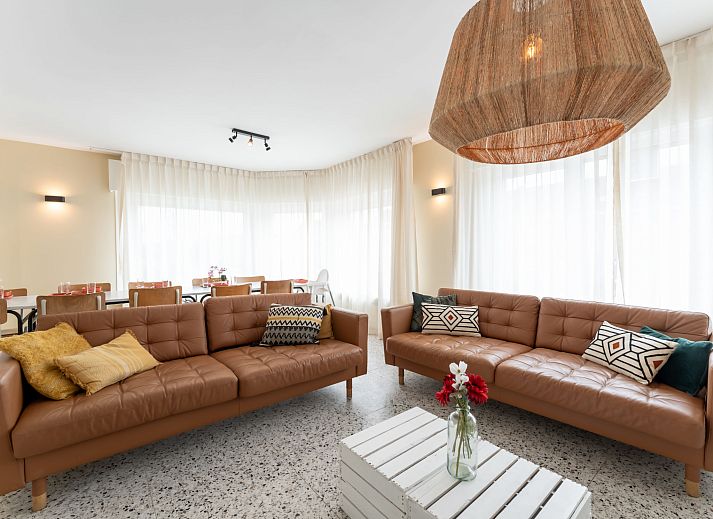 Stijlvolle woonkamer in Vakantiehuis Wanderlust Belgium met comfortabele banken, gelegen in Blankenberge aan de Belgische kust.