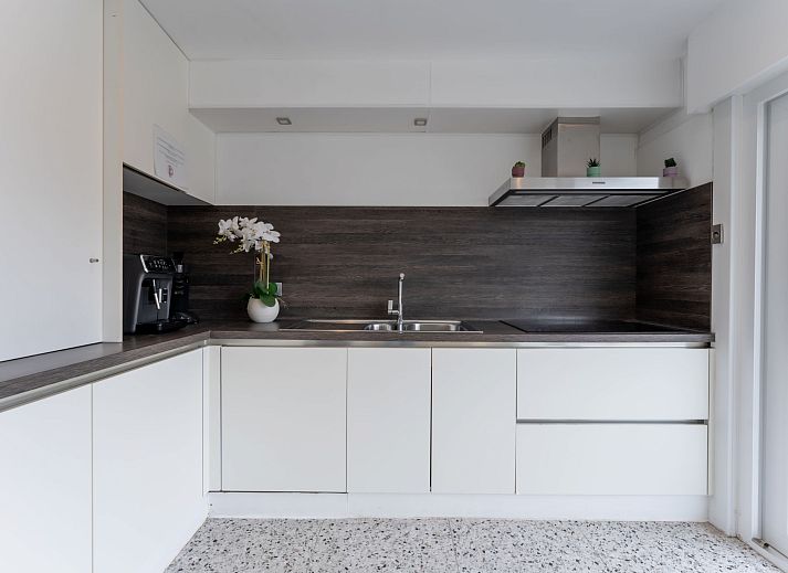 Stijlvolle woonkamer in Vakantiehuis Wanderlust Belgium met comfortabele banken, gelegen in Blankenberge aan de Belgische kust.
