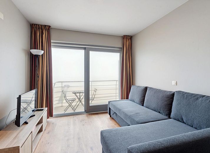 Gezellig woonkamerinterieur van Ocean Suites - 1004, vakantiehuis aan de Belgische kust in Blankenberge, met uitzicht op het terras.