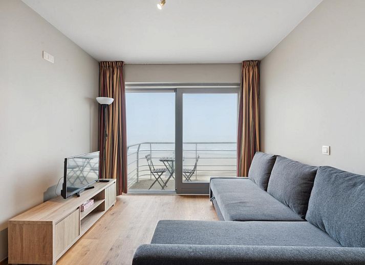 Gezellig woonkamerinterieur van Ocean Suites - 1004, vakantiehuis aan de Belgische kust in Blankenberge, met uitzicht op het terras.